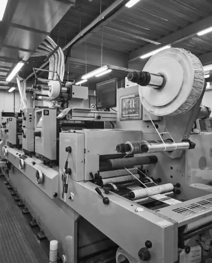 高速で稼働する印刷機が紙にカラー印刷をしている様子