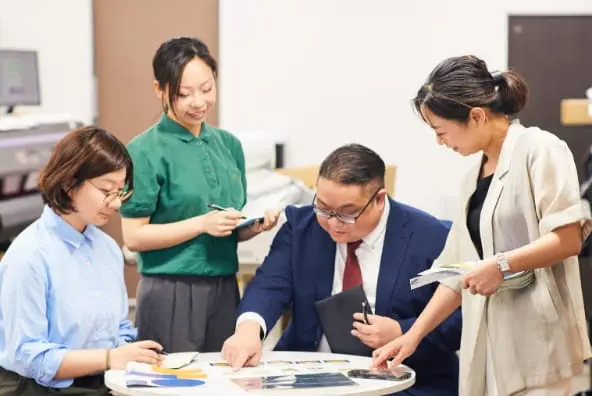 オフィスで資料を確認しながら打ち合わせをするビジネスパーソン